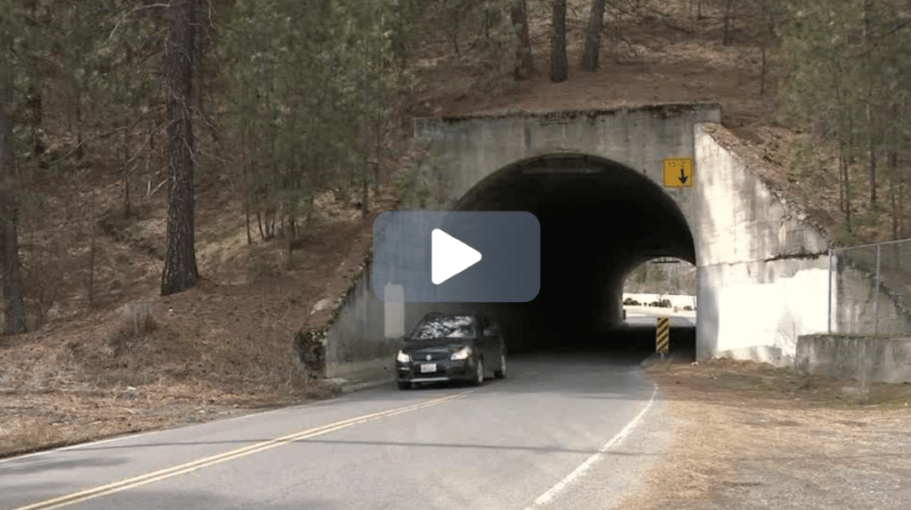 Car driving under a concrete bridge